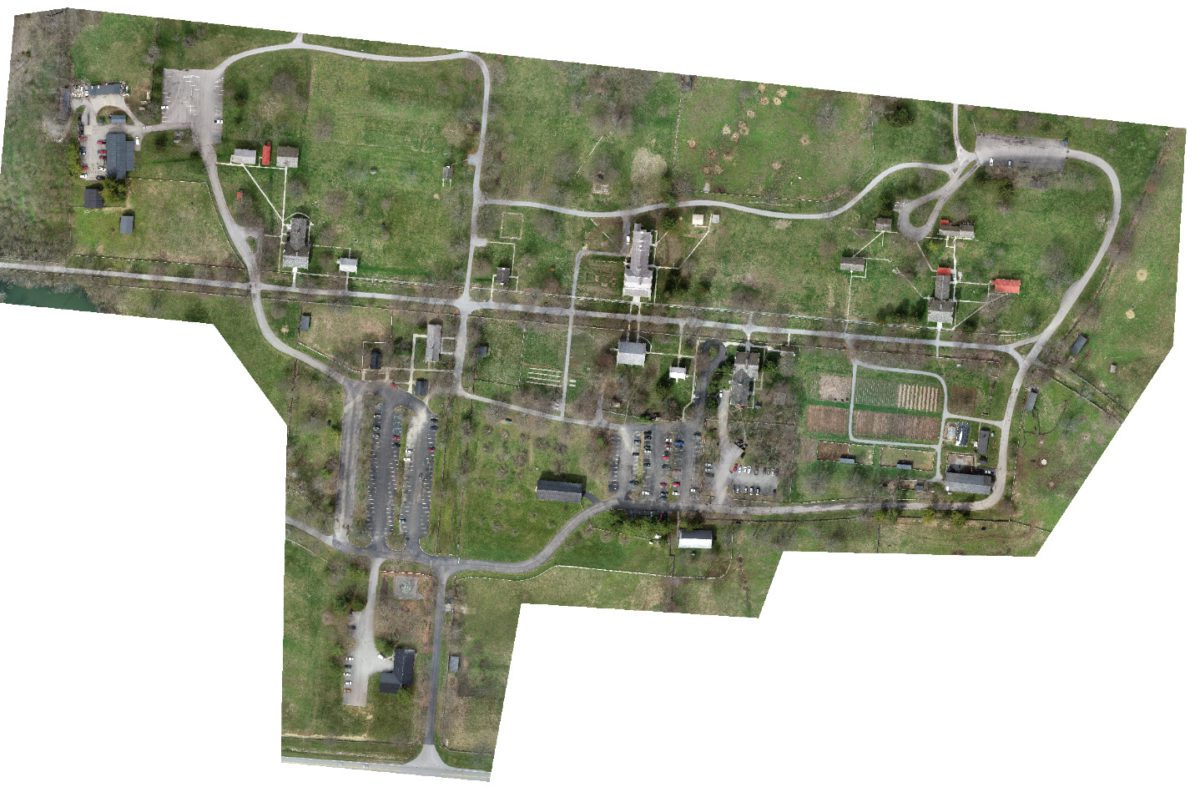 An aeiral view of a building's property with grassland and roads