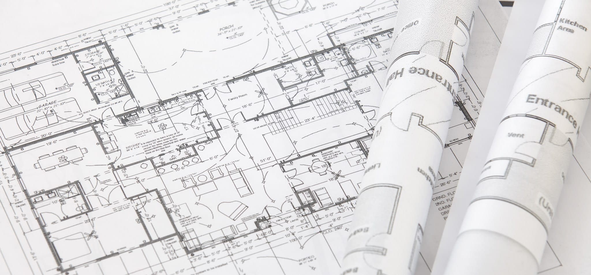 A CAD drawing of a building with two rolled up blueprints on top of it.